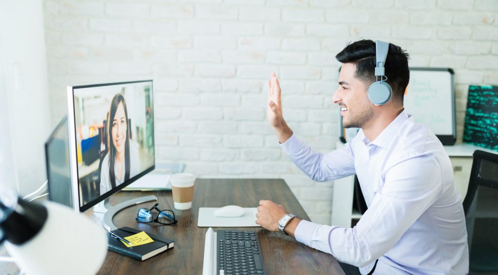 A men waving to a colleague during video call