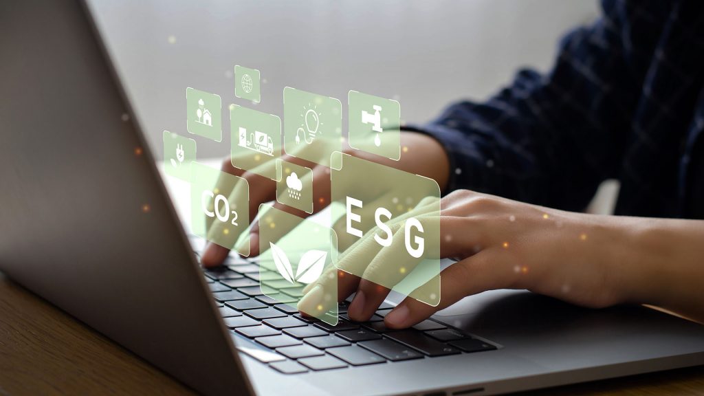 Young man sitting using a computer to analyze ESG, environment, conservation, society, governance, close to the computer screen in business investment strategy concept.